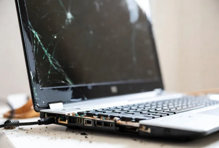 Gebrochenes Laptop-Scharnier mit sichtbarem Gehaeuseschaden wird repariert